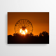 Das Foto zeigt ein Riesenrad, hinter welchem die Sonne untergeht. Die gold strahlende Abendsonne bietet in Kombination einen atemberaubenden Sonnenuntergang.