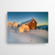 Das Akustikbild zeigt eine Holzhütte, die auf einem Berg im Tiefschnee steht. Die Hütte ist durch das Sonnenlicht in warme Farbtöne getaucht. Vor der Hütte sieht man die Spuren im tiefen Schnee.
